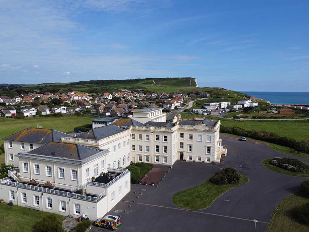 Large rental property on seafront with cliffs in background