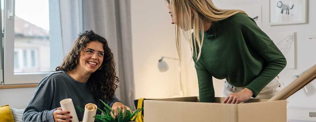 two-female-tenants-moving-into-a-flat-unpacking-boxes