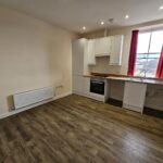 unfurnished studio flat with window with views over rooftops.